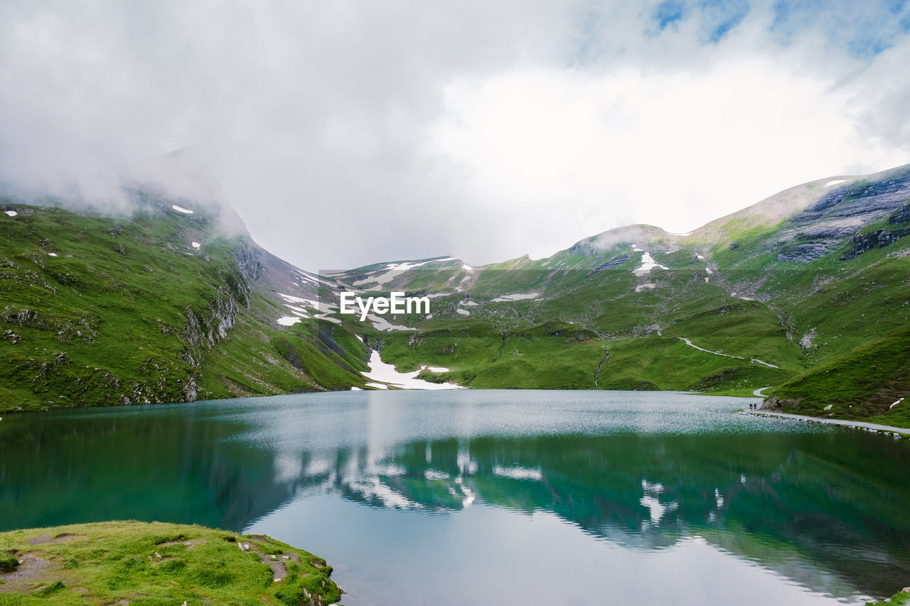 LAKE BY MOUNTAINS AGAINST SKY