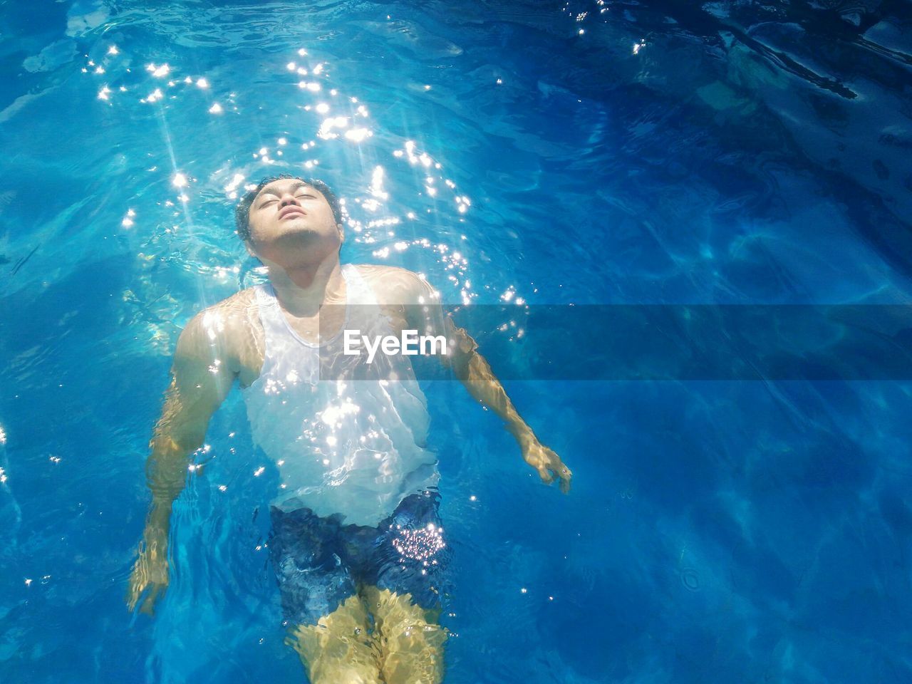 HIGH ANGLE VIEW OF GIRL SWIMMING IN POOL