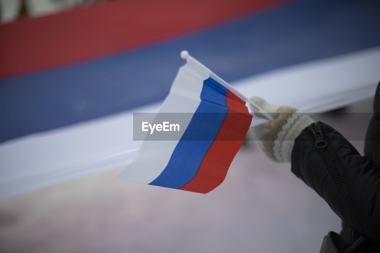 Flag of russia in hand. symbol of state of russian federation. national flag.