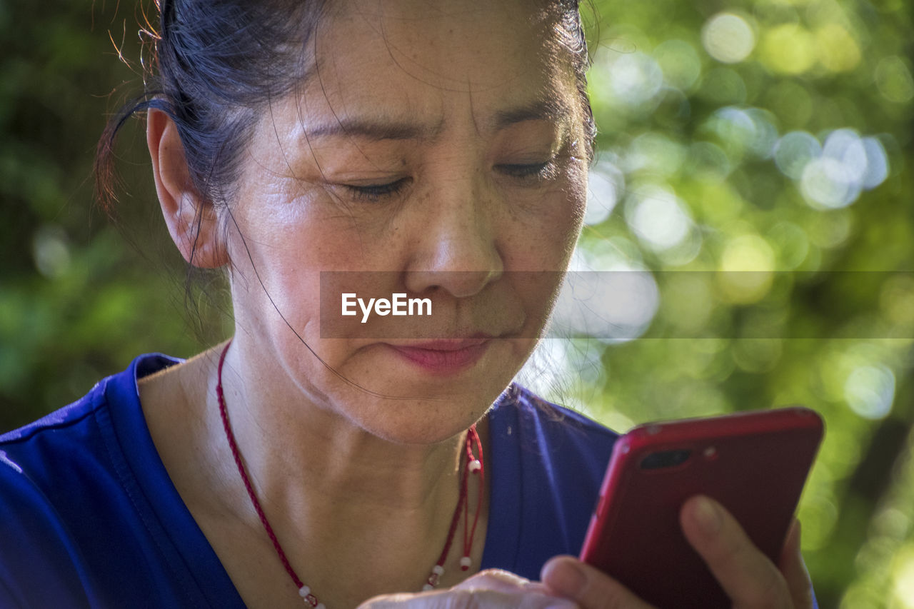 CLOSE-UP PORTRAIT OF WOMAN WITH MOBILE PHONE