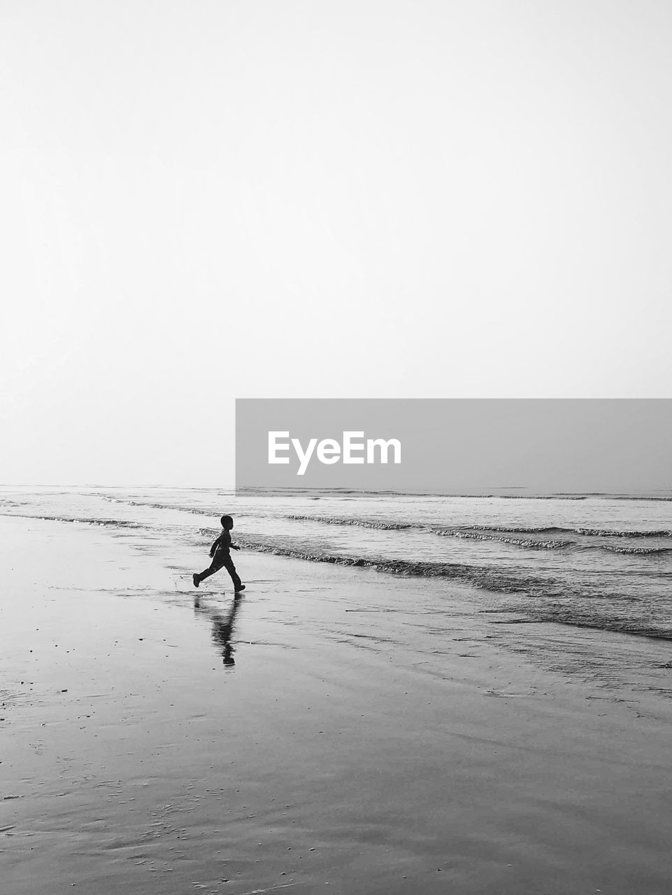 Man on beach against clear sky