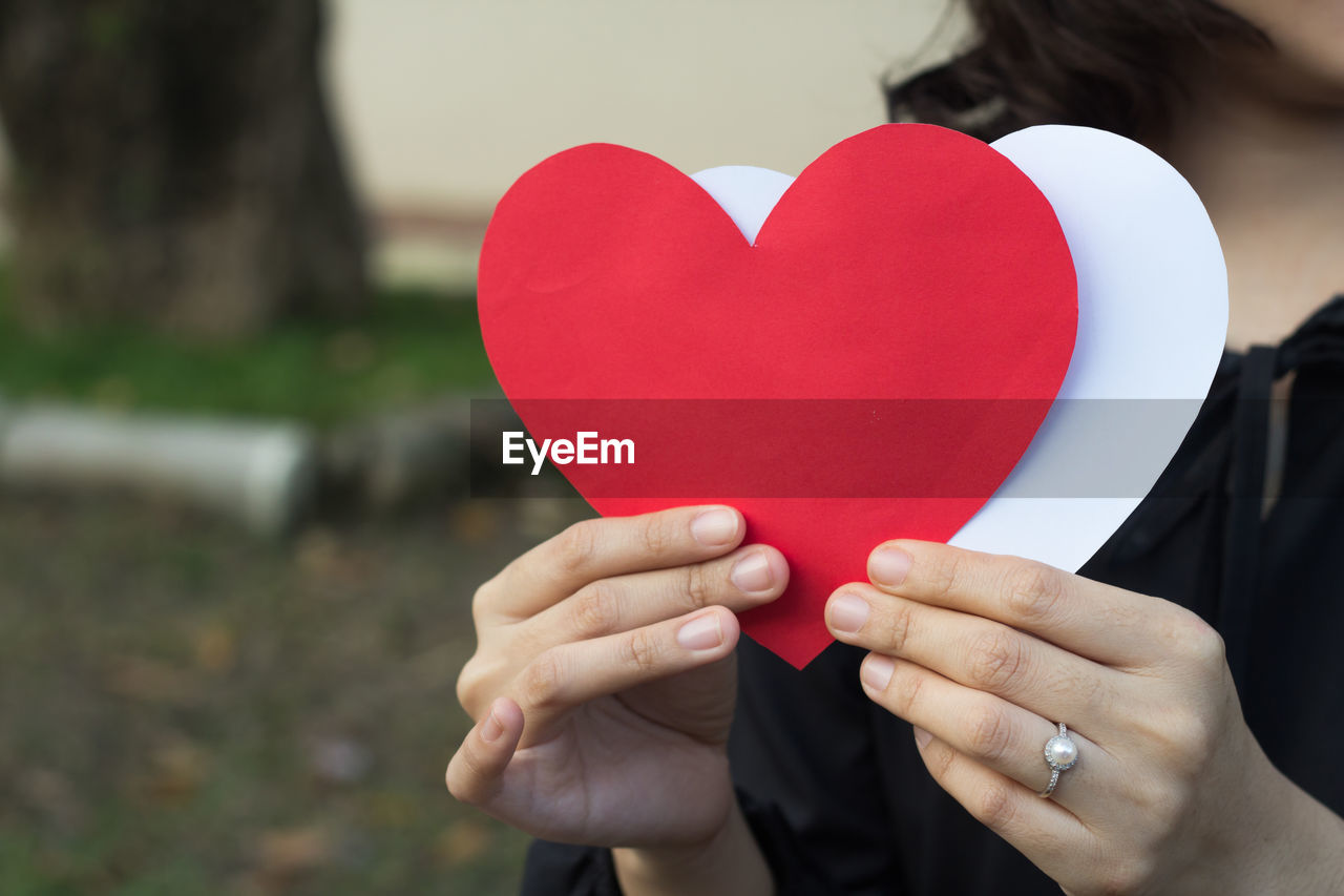 CLOSE-UP OF WOMAN HOLDING HEART SHAPE BALLOON