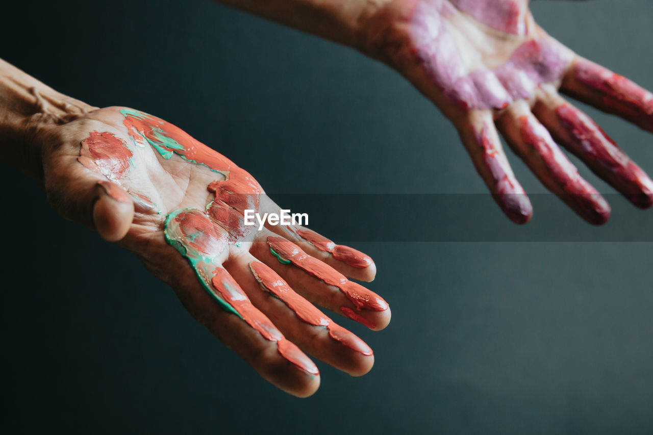 Paint on hands against gray background