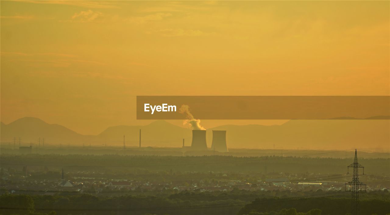 SMOKE EMITTING FROM CHIMNEY AGAINST SKY DURING SUNSET