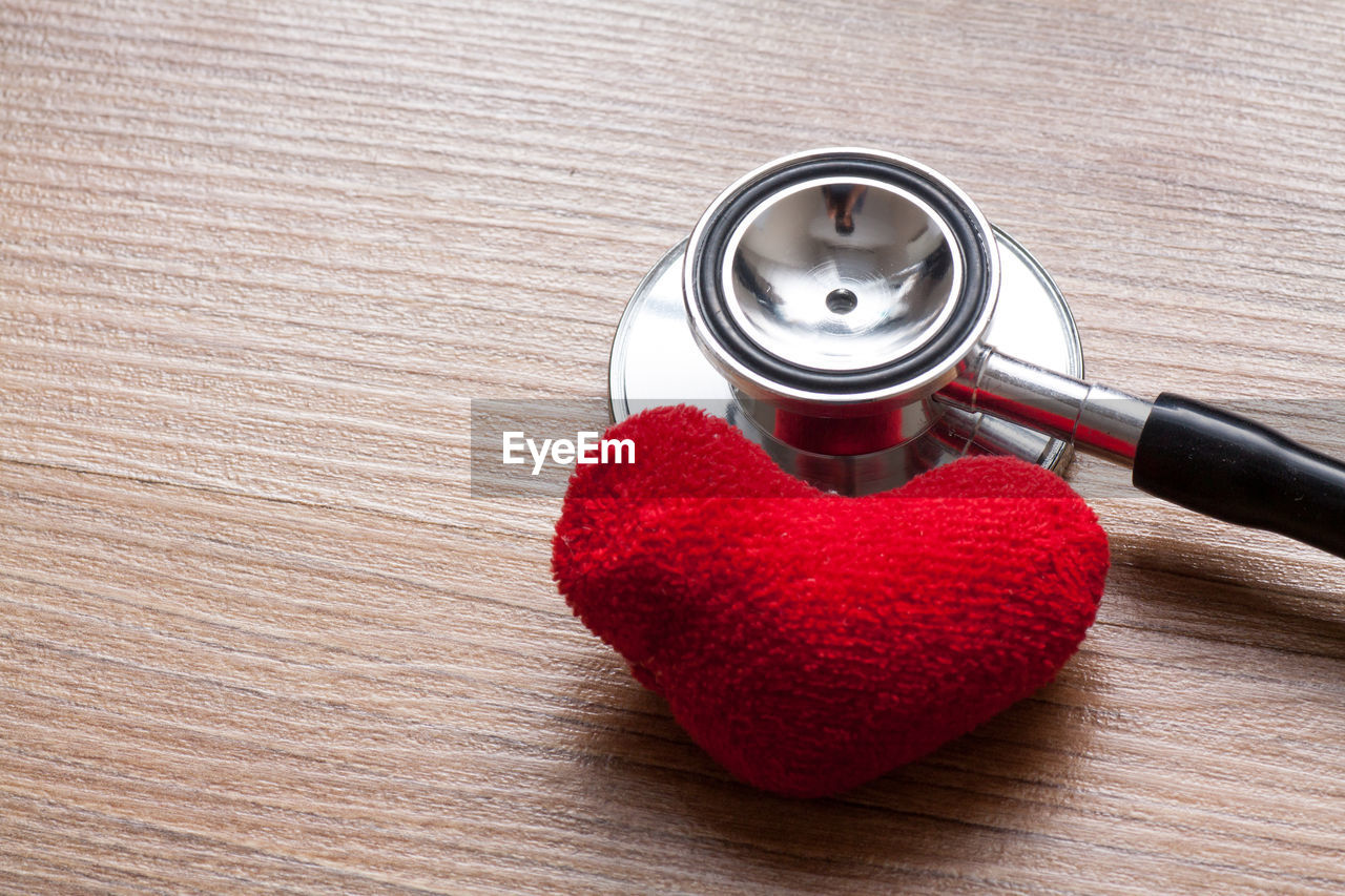 High angle view of heart shape and stethoscope on table