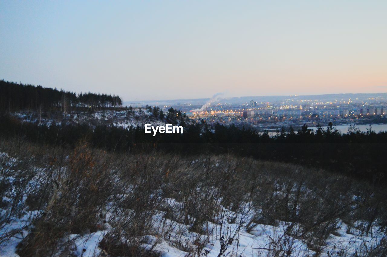 Scenic view of field against clear sky during winter