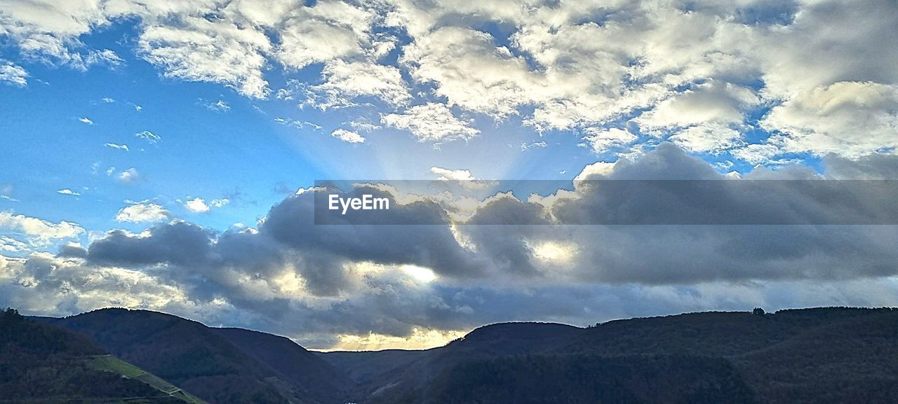 sky, cloud, mountain, environment, beauty in nature, scenics - nature, landscape, nature, mountain range, no people, horizon, tranquility, sunlight, land, outdoors, travel, blue, tranquil scene, travel destinations, dramatic sky, cloudscape, idyllic, day, non-urban scene, tourism, sunbeam