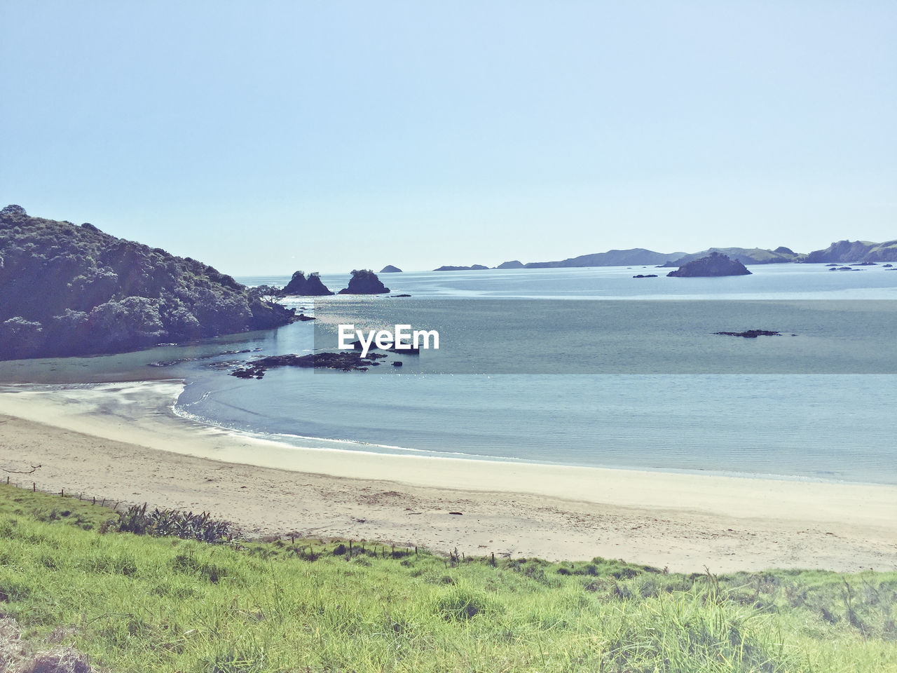 View of calm beach against clear sky