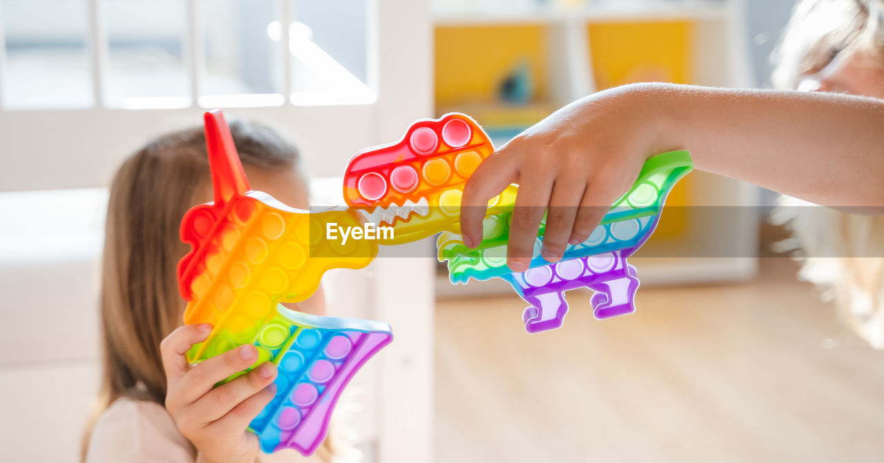 MIDSECTION OF WOMAN PLAYING WITH TOYS