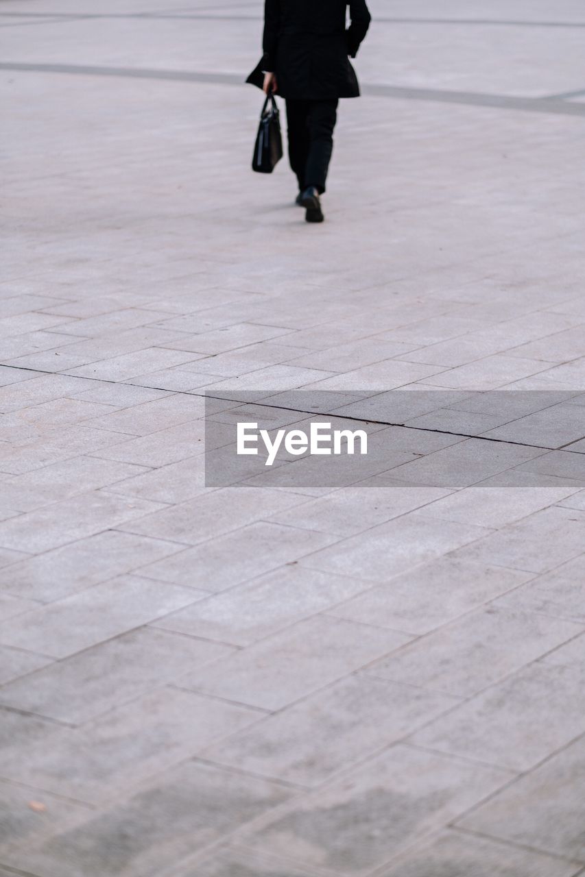 Low section of man walking on street