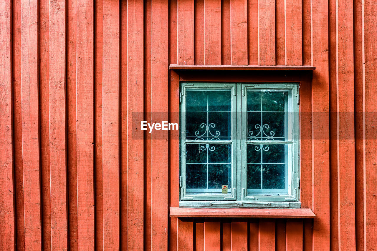 Close-up of window on red wall