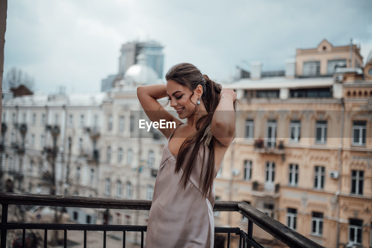 Young woman photographing with city in background