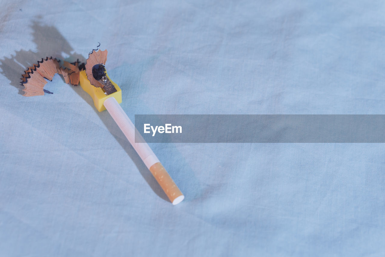 HIGH ANGLE VIEW OF PENCILS ON WHITE TABLE