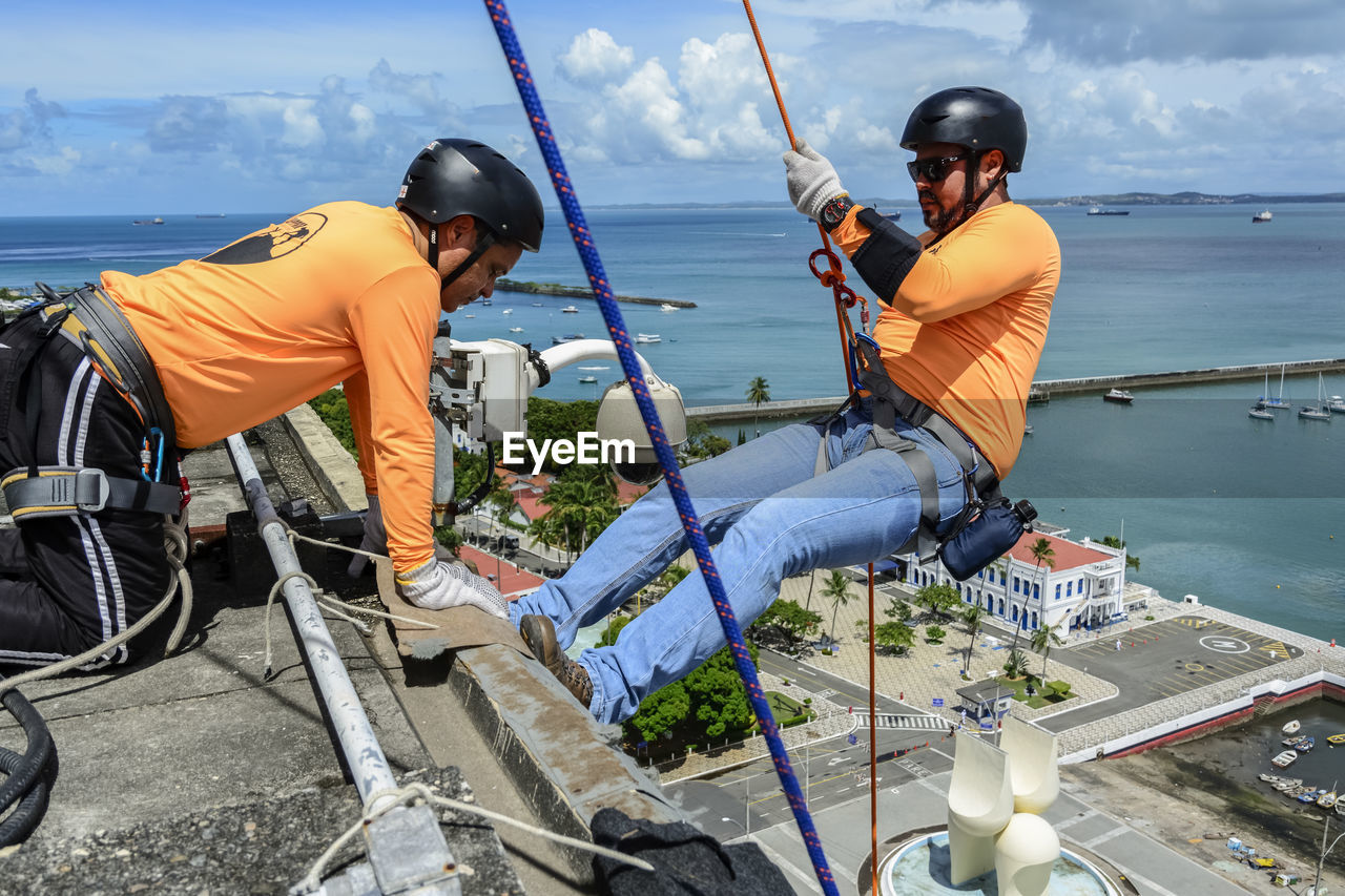  man with helmet, glove and equipment practicing rappel 