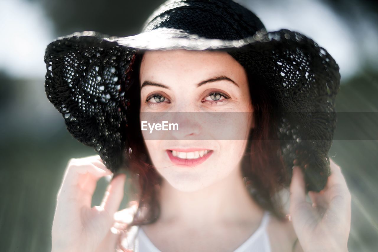 Portrait of smiling young woman wearing hat