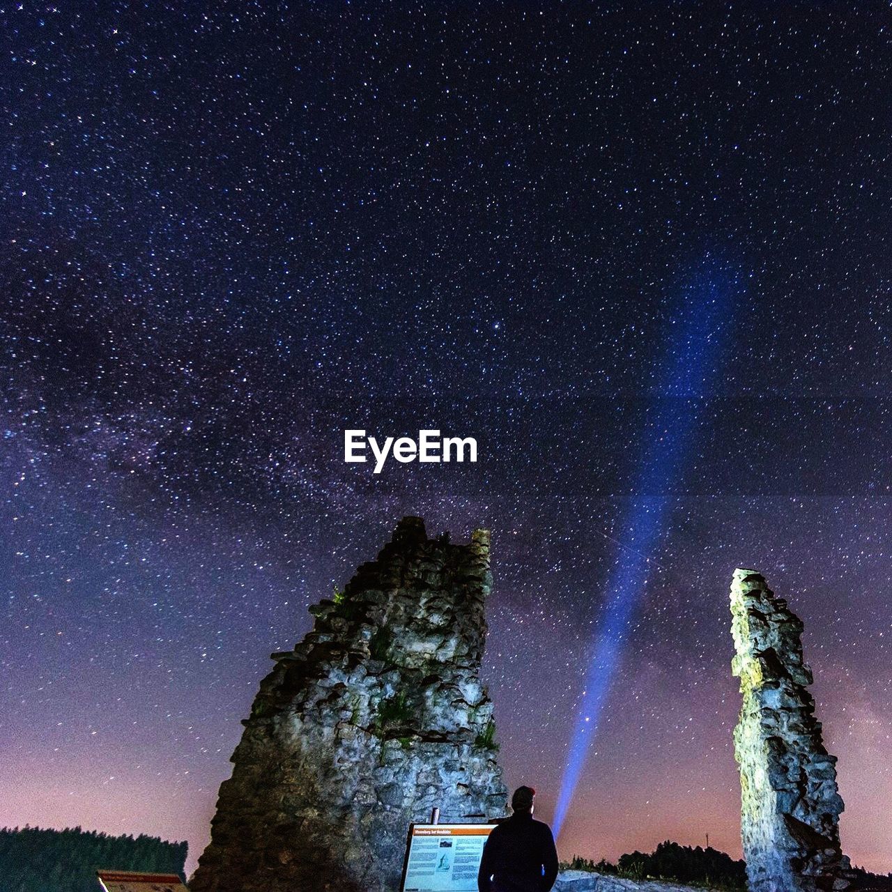 Low angle view of silhouette man standing against star field