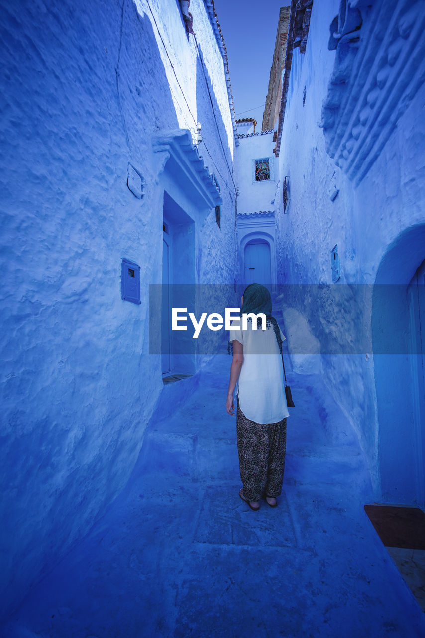 "The Blue City" We travelled from Sevilla to Tarifa, then took a ferry to Tangier, then a taxi to Chefchaouen, Morocco. EyeEmNewHere a new beginning Chefchaouen Morocco Beauty Blue City Blue Medina Architecture Built Structure One Person Building Lifestyles Women Adult Walking The Way Forward Direction Digital Nomad Building Exterior Leisure Activity Day Standing Men Clothing Outdoors Real People Rear View Full Length Alley Warm Clothing