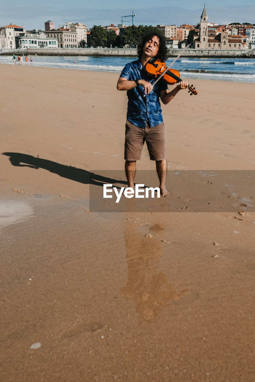 Full length portrait of man standing on beach