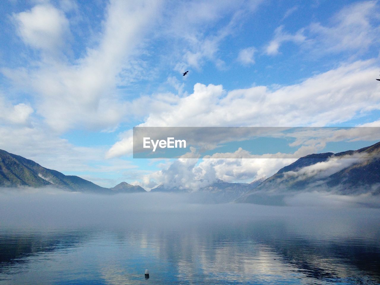 SCENIC VIEW OF LAKE BY MOUNTAIN AGAINST SKY