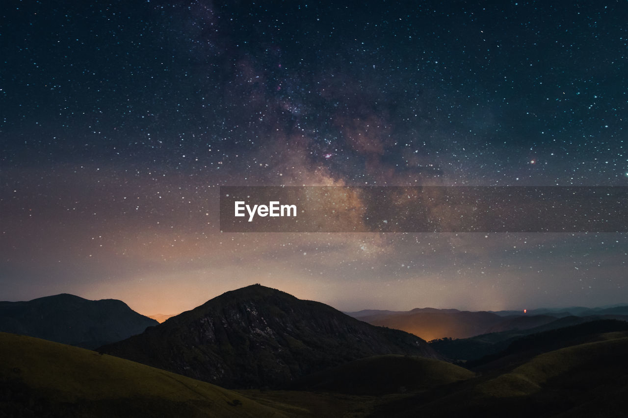 Scenic view of mountains against sky at night