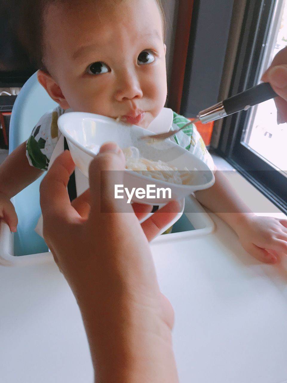 CLOSE-UP OF CUTE BABY EATING ICE CREAM
