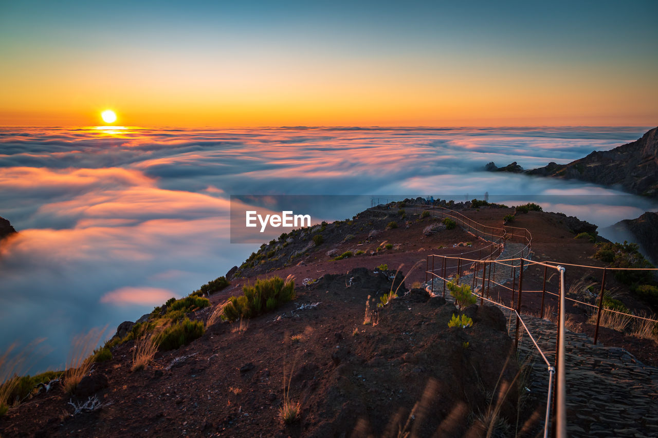 SCENIC VIEW OF MOUNTAINS AGAINST ORANGE SKY