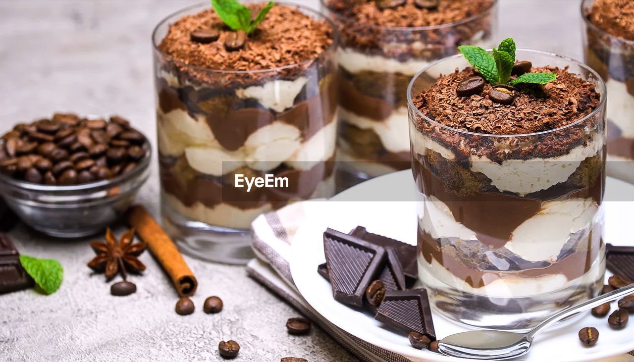 Dessert with chocolate, cinnamon, coffee and whipped cream in a glass glass