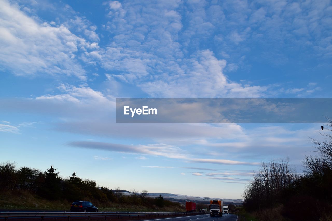 VIEW OF ROAD AGAINST CLOUDY SKY