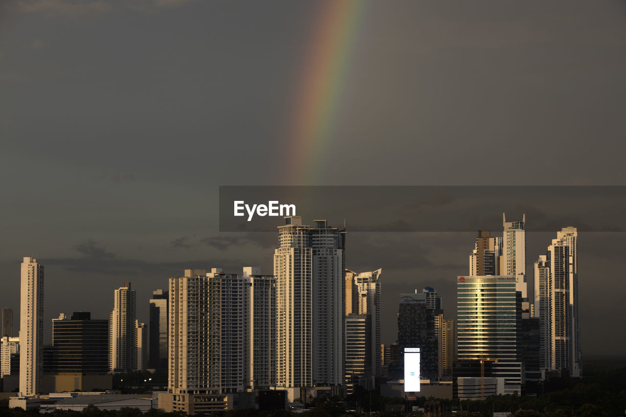rainbow, city, building exterior, architecture, sky, built structure, landscape, office building exterior, skyscraper, building, urban skyline, cityscape, skyline, nature, cloud, metropolitan area, horizon, residential district, no people, dusk, beauty in nature, travel destinations, outdoors, scenics - nature, downtown district, water, night, dramatic sky, city life, sunset, metropolis, evening, environment, tower block, multi colored, illuminated, travel