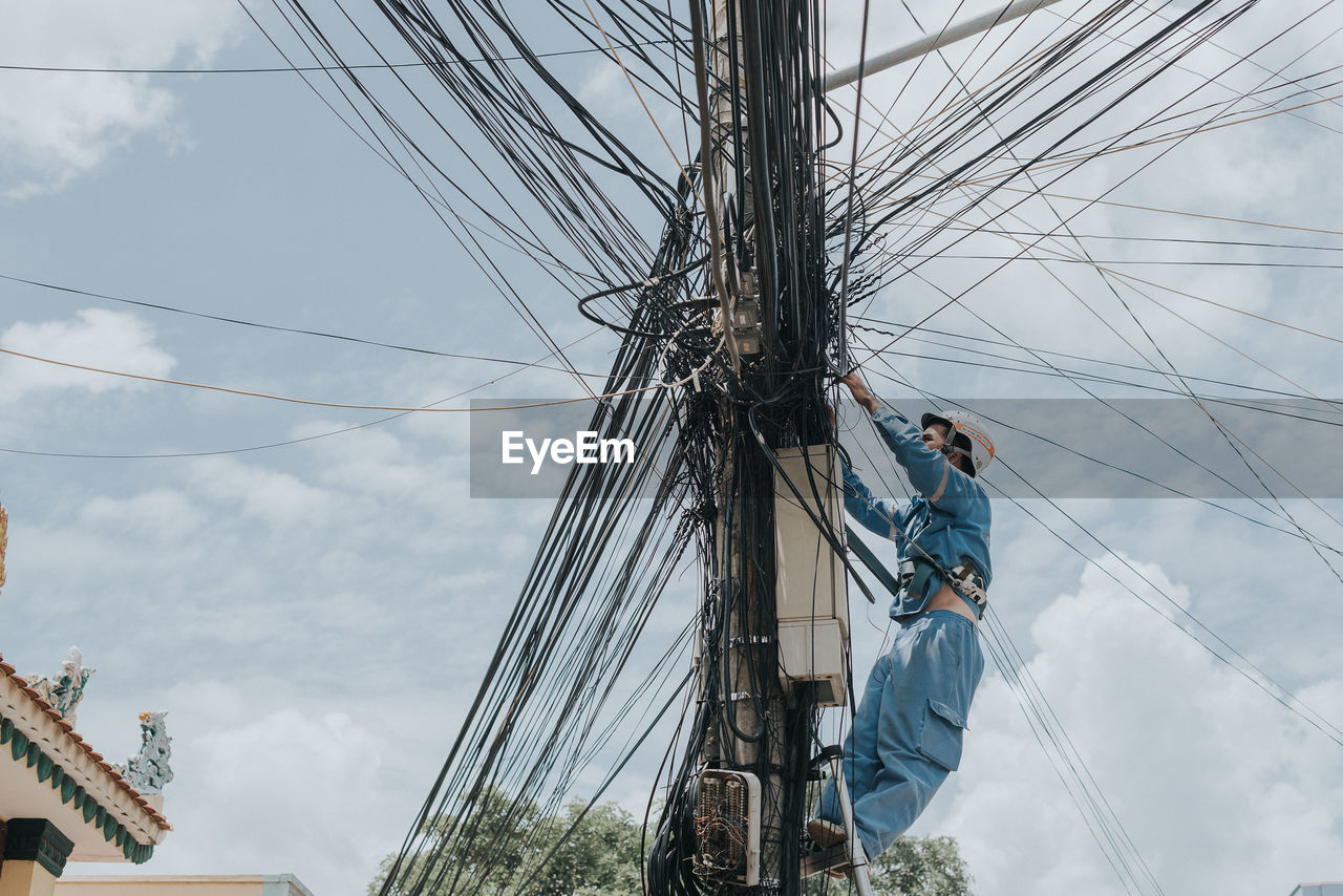 LOW ANGLE VIEW OF PEOPLE WORKING ON SAILBOAT