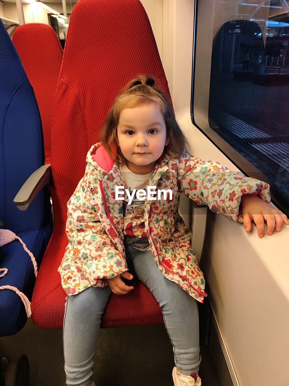 PORTRAIT OF HAPPY GIRL SITTING IN BUS