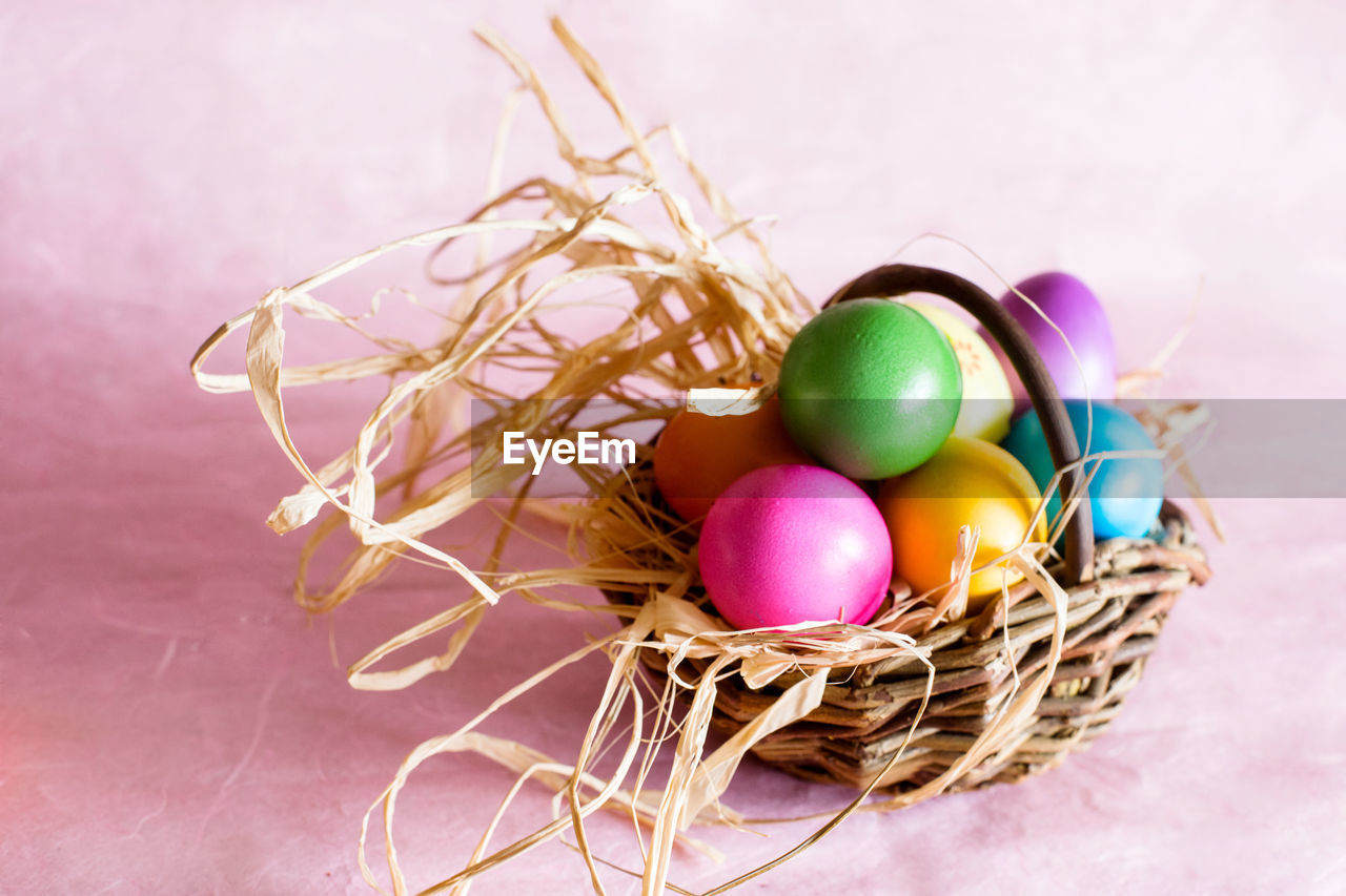 Close-up of colorful easter eggs in wicker basket on table