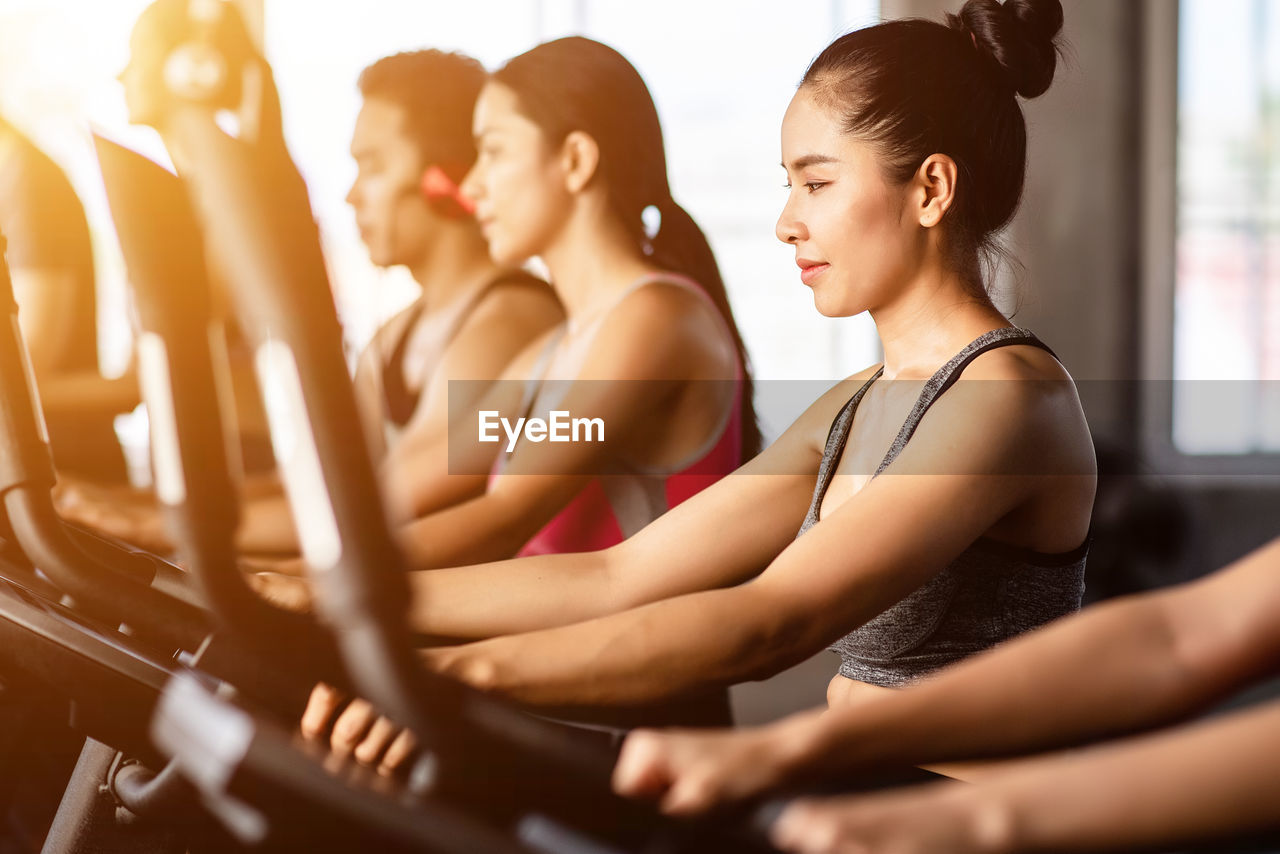 Mid adult woman running on treadmill in gym