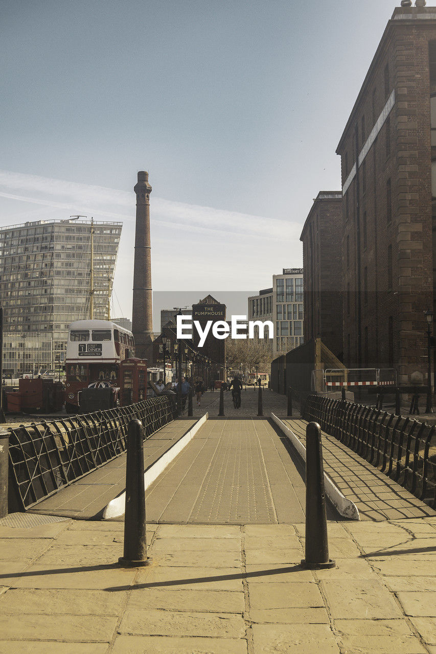 Low angle view across footbridge towards the city beneath a blue sky with copy space 