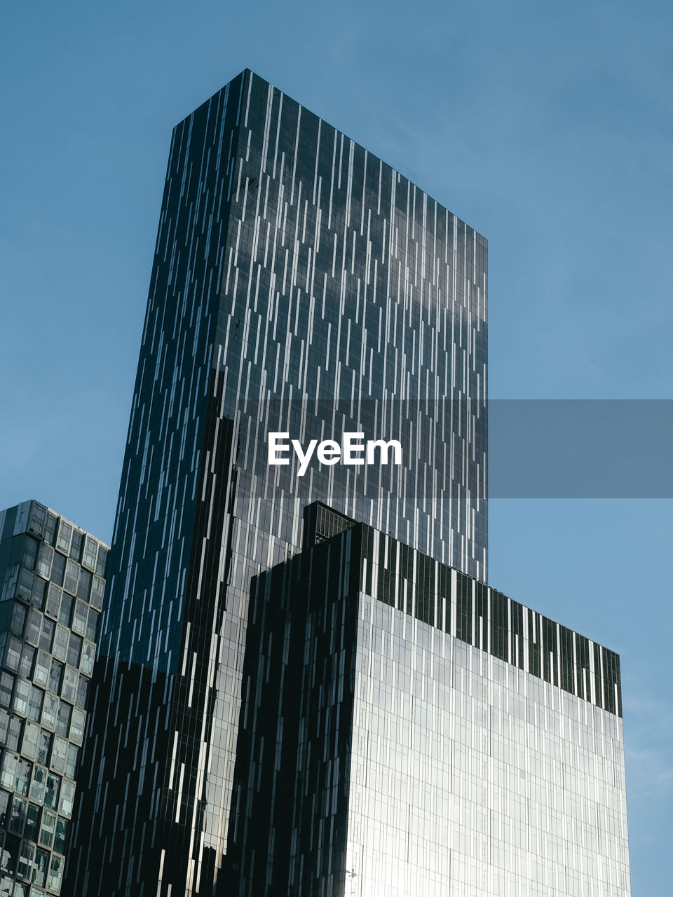 Low angle view of modern glass building against clear sky