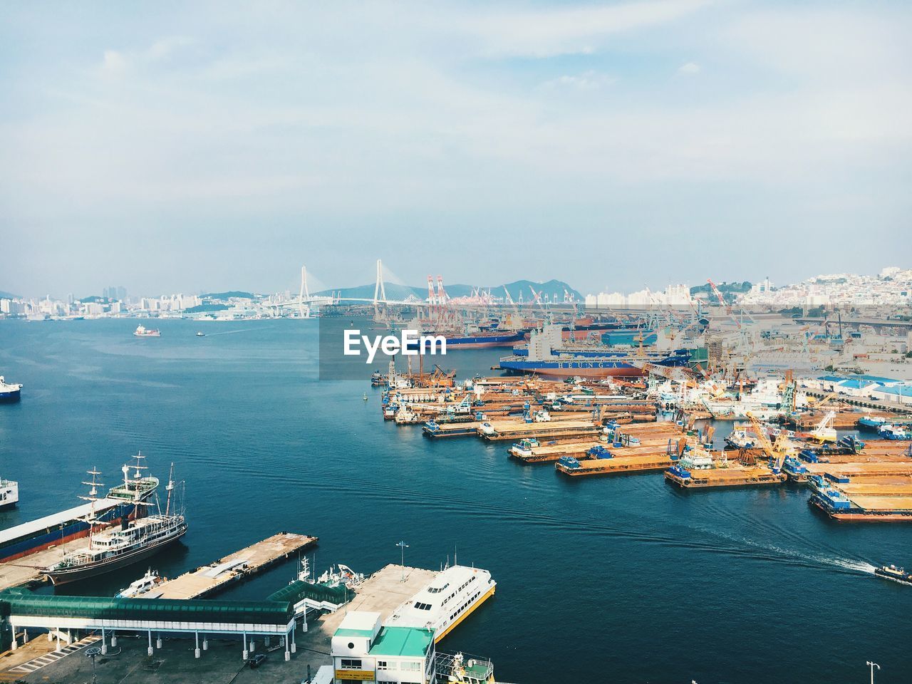 Boats moored at harbor against sky