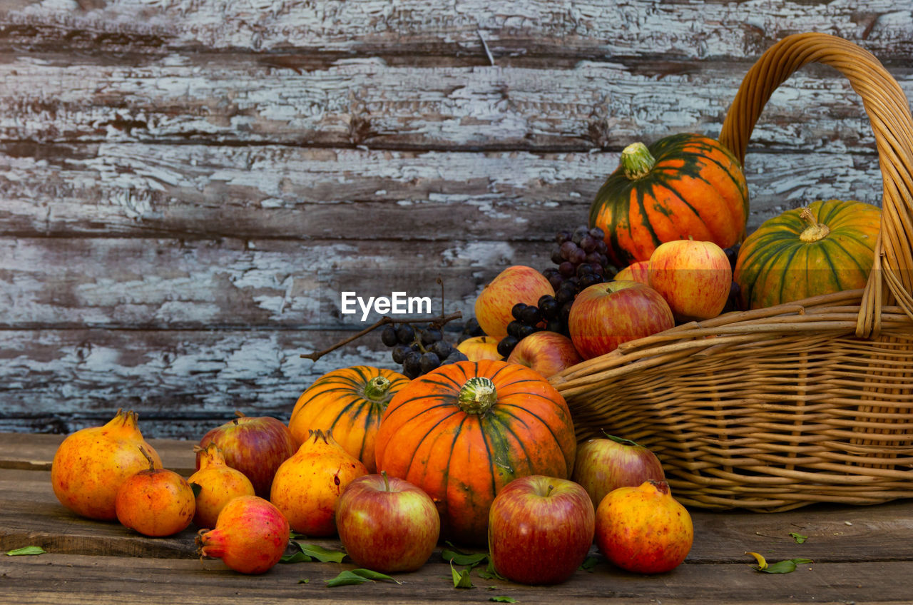 Basket full of pumpkins, apples and various autumn fruits and flowers