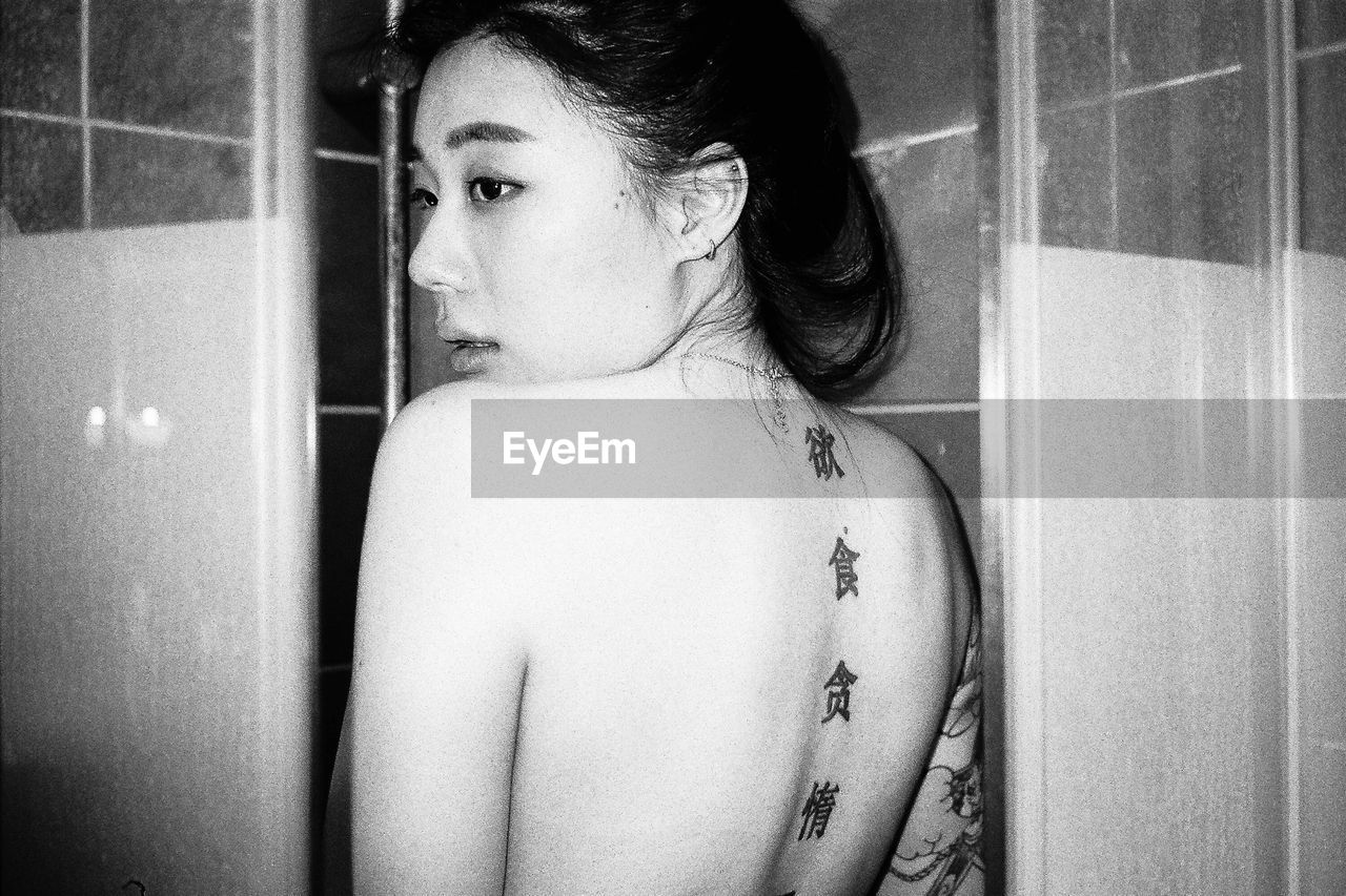 Close-up of woman with chinese tattoos