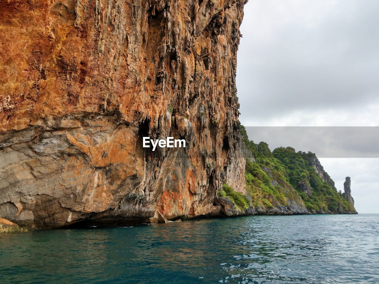 Rock formations by sea against sky