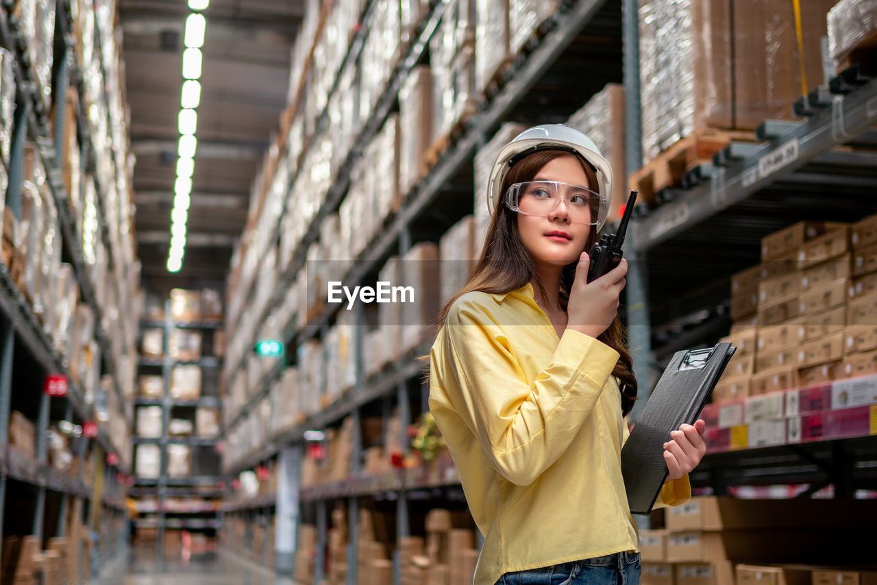 Female warehouse worker inspecting a warehouse in a factory. 