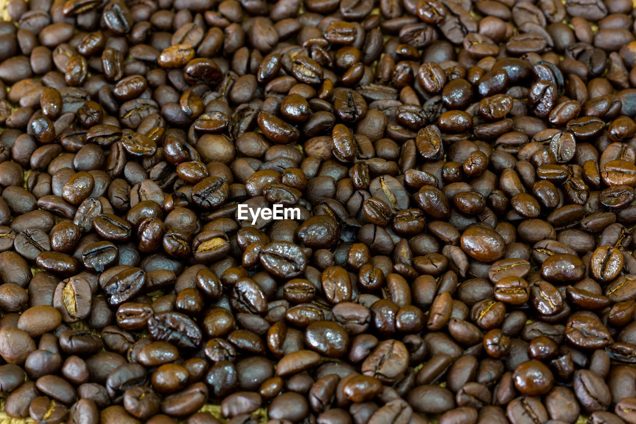 FULL FRAME SHOT OF ROASTED COFFEE BEANS IN BACKGROUND