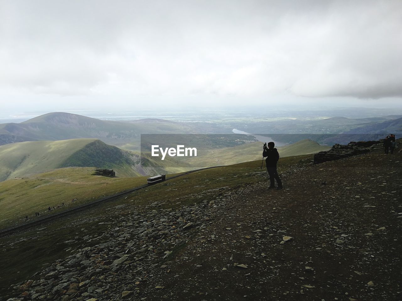 Teenage girl photographing while standing on mountain