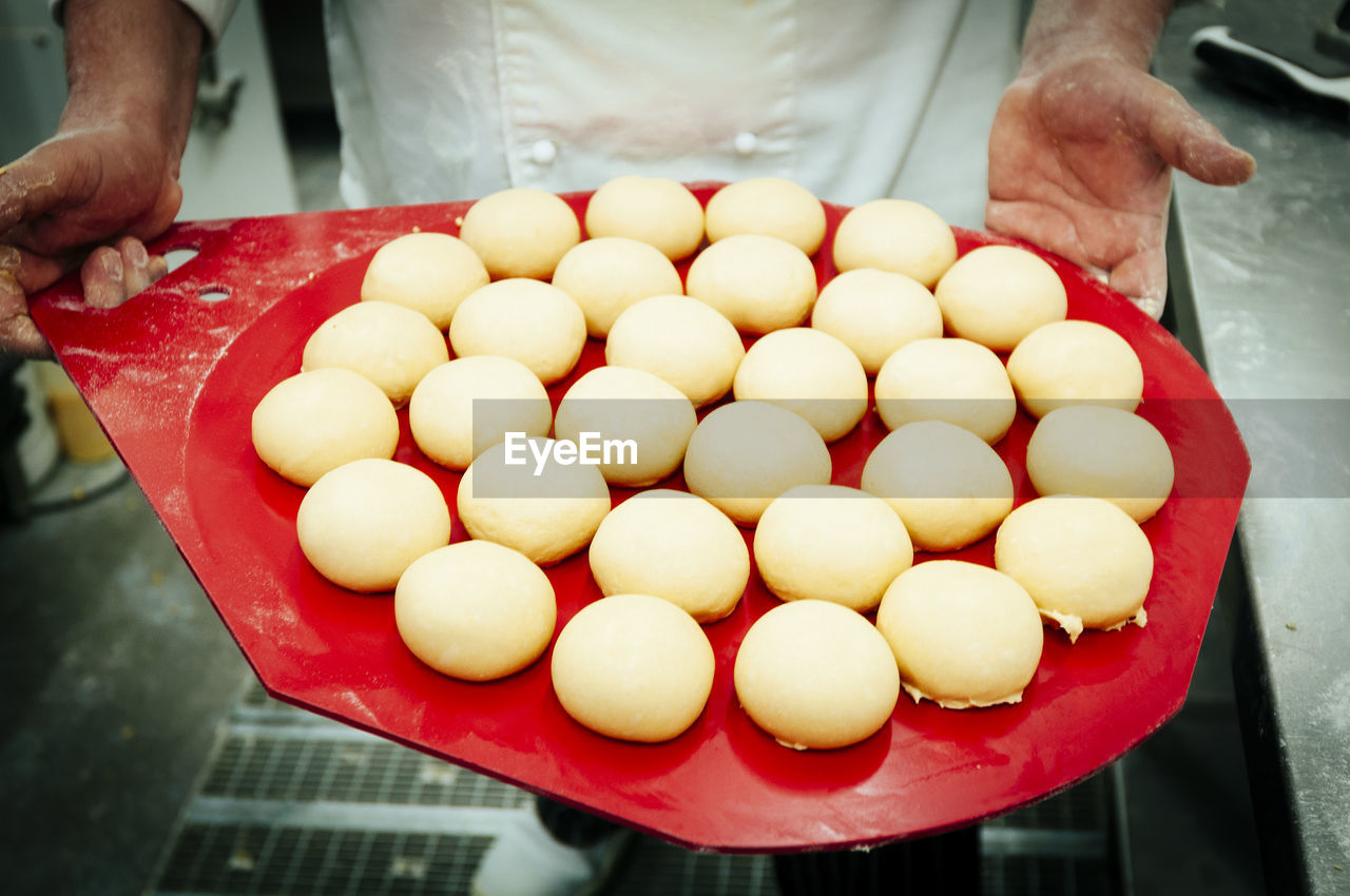 Close-up of chef holding dough in commercial kitchen