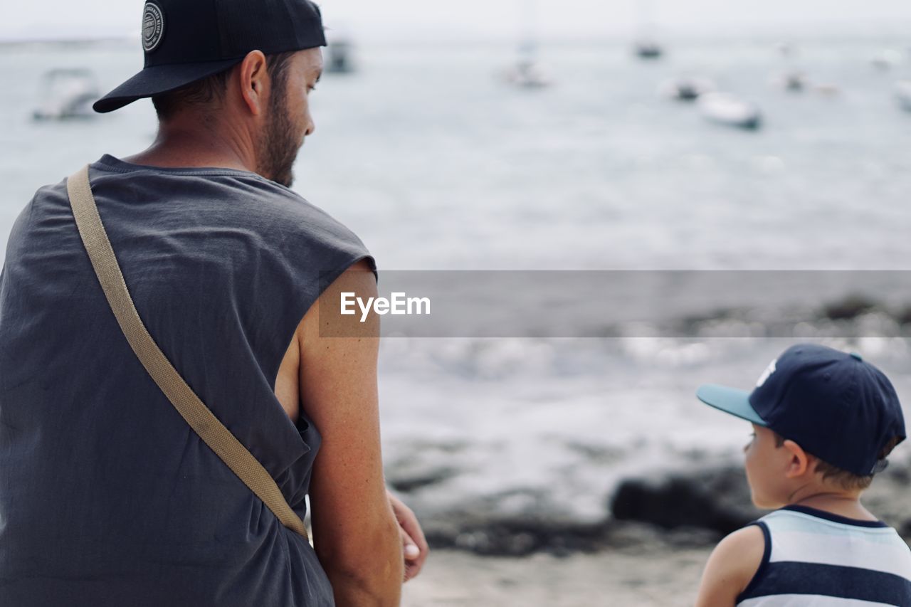 Rear view of a father and son at the beach