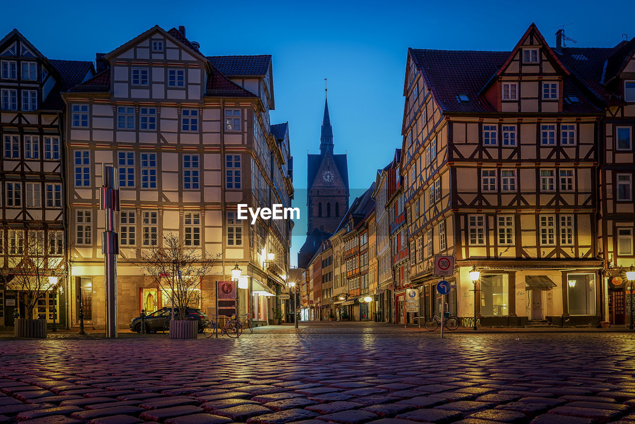 Street amidst buildings in city at night