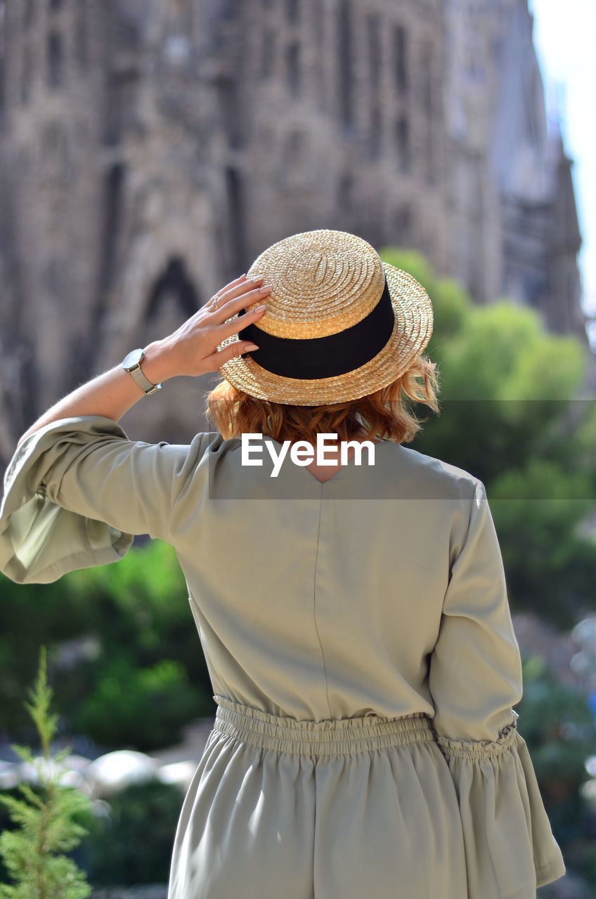 Rear view of woman wearing hat standing outdoors