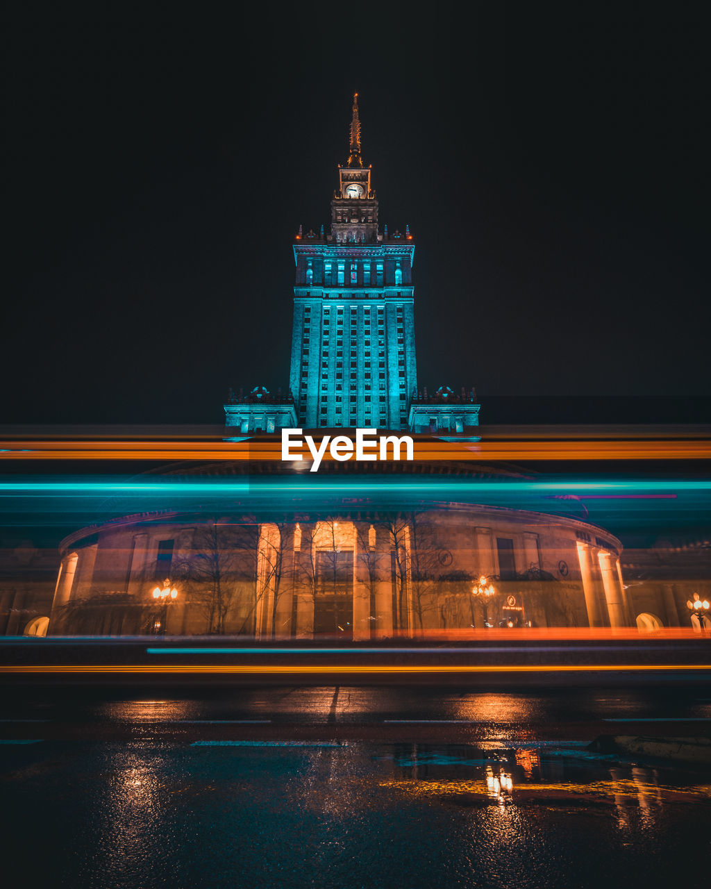 LIGHT TRAILS ON ILLUMINATED CITY AT NIGHT