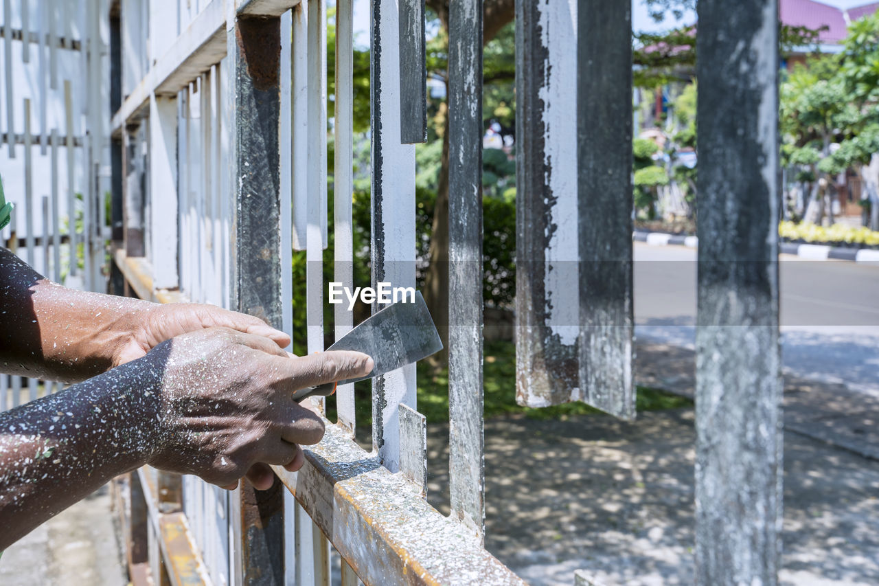 Midsection of man working on railing