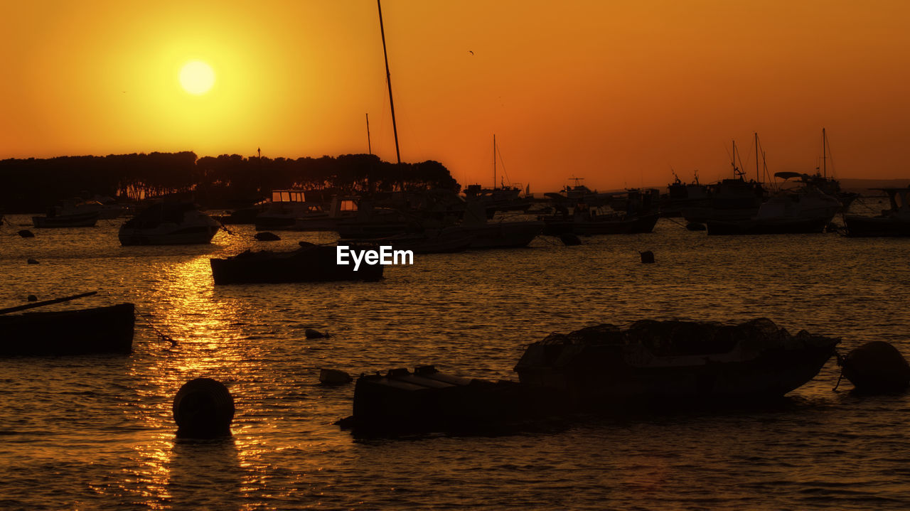 SILHOUETTE SAILBOATS ON SEA AGAINST ORANGE SKY