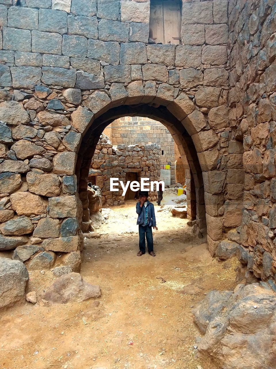 FULL LENGTH OF MAN AND WOMAN STANDING AGAINST OLD BUILDING